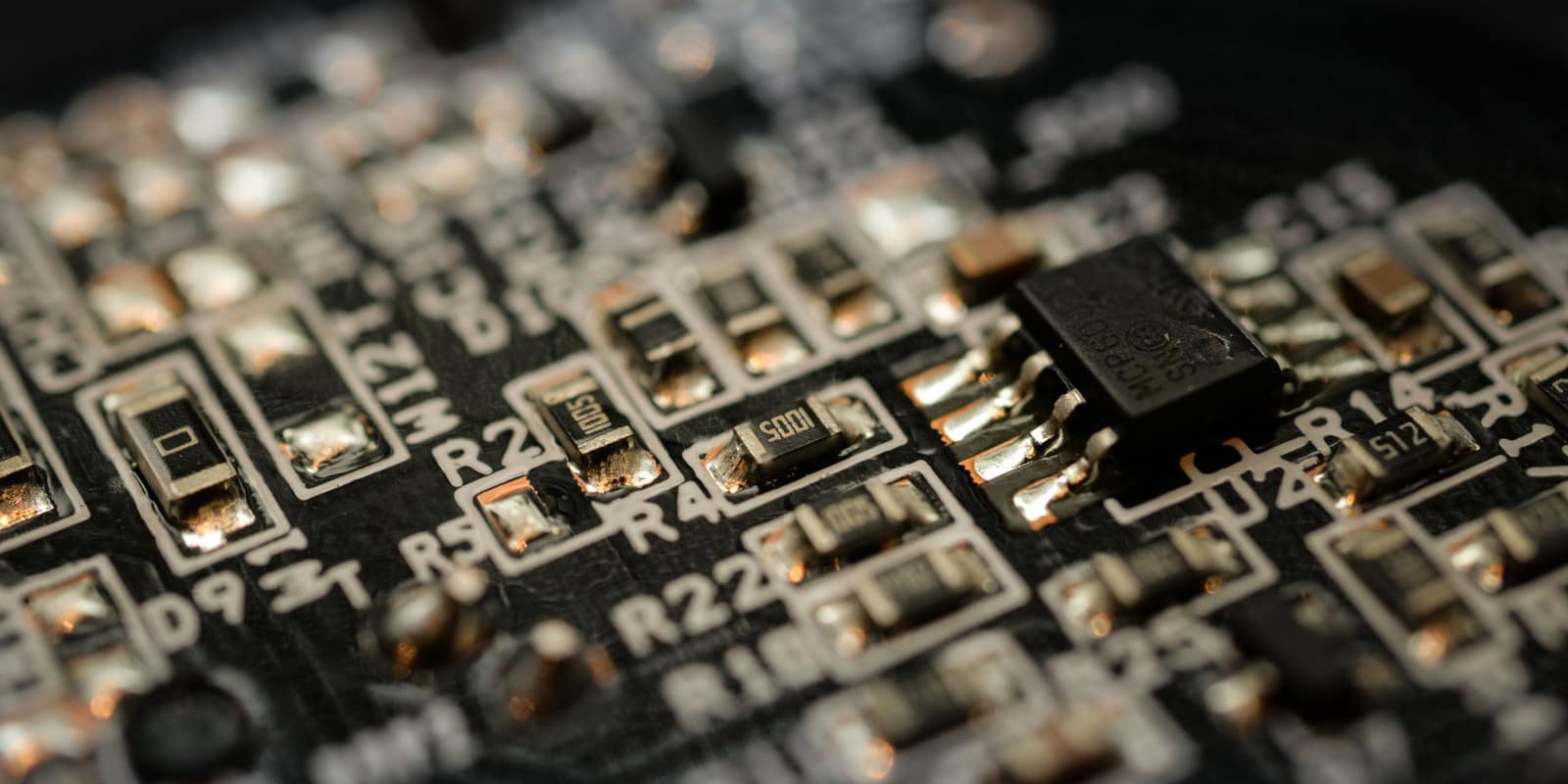 Macro photograph of a populated circuit board, component labels in focus
